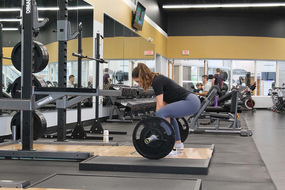 working out woman lifting barbell gym